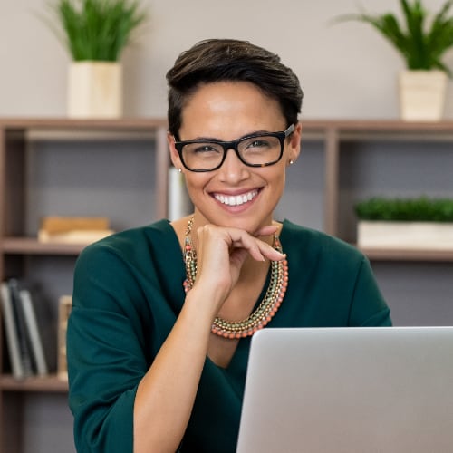 woman at desk in glasses and smiling