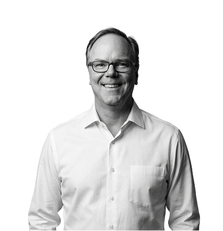 IncWorx employee, Rich, smiling for his headshot. He is sporting a white collared shirt and black framed glasses.