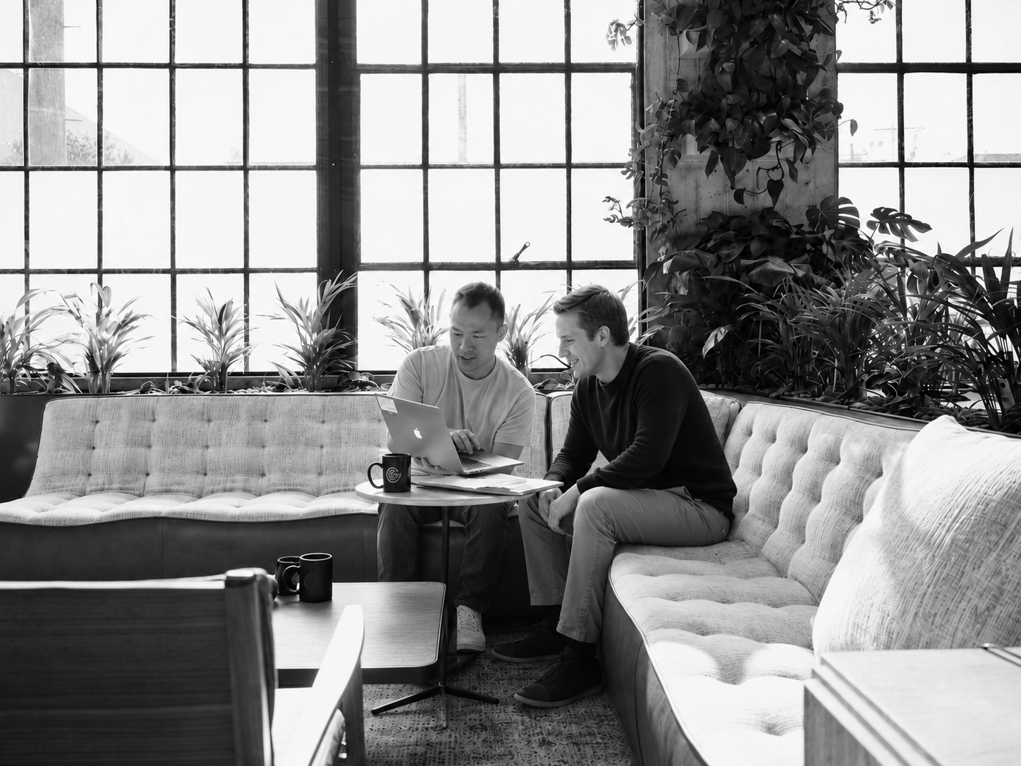 Microsoft consultants collaborate over a laptop in a modern workspace, representing consulting services, teamwork, and technology strategy.