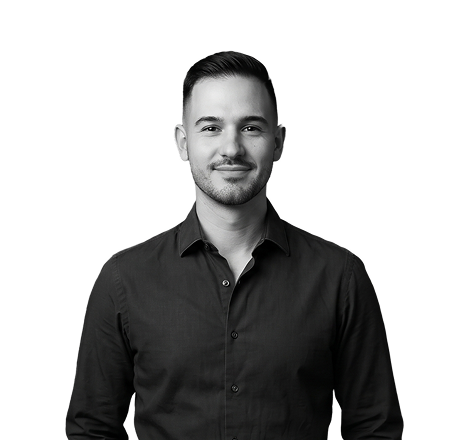IncWorx consultant, Joshua, standing and smiling in a black collared shirt.