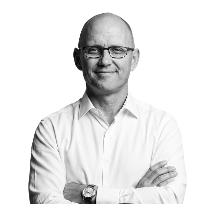 IncWorx President, Jonathan, standing with arms crossed casually in front of him. He is sporting a white collared shirt and black framed glasses.