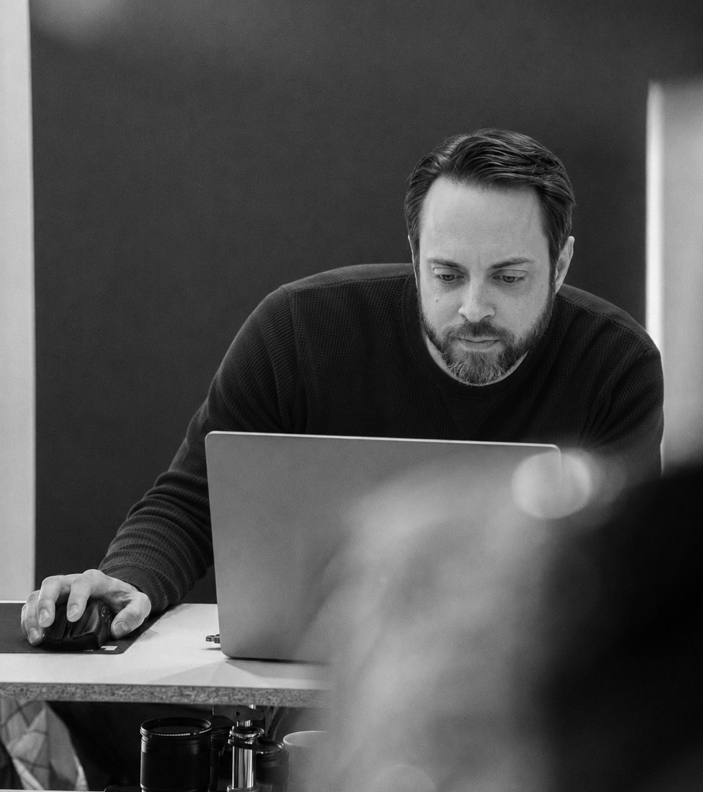 Technology consultant focused on work at a laptop in a modern office workspace.