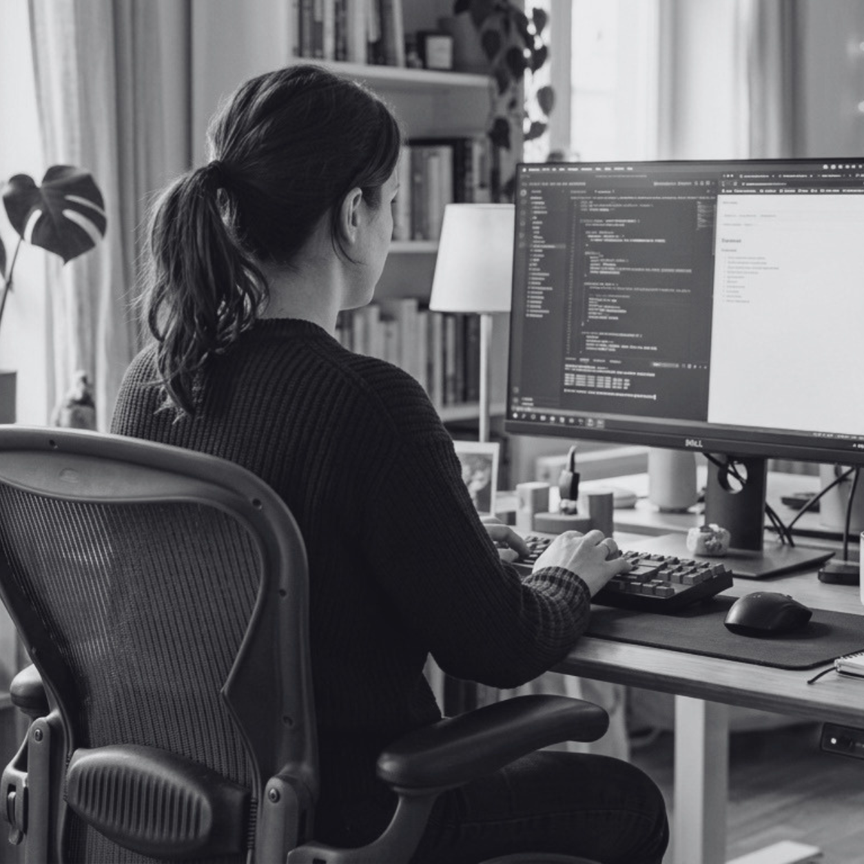 Black-and-white image of a woman working on an employee onboarding automation.