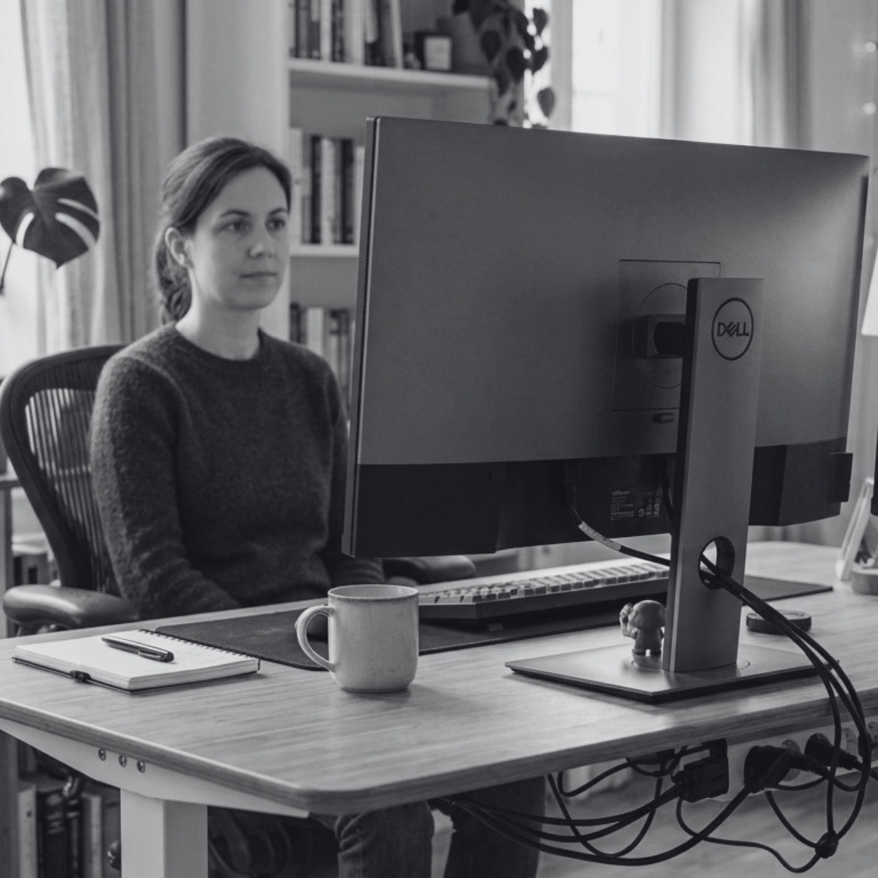 Black-and-white image of a woman working on an employee onboarding automation.
